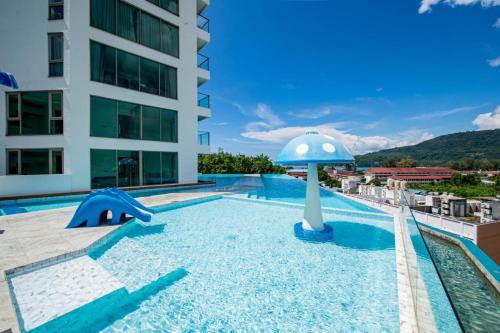 a swimming pool with an umbrella in a building at Deluxe Twin Bed Apartment by Renttini in Kamala Beach