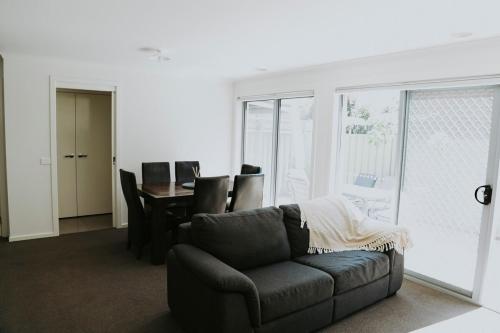 a living room with a couch and a table with chairs at Spacious Stay On Shamrock, Bendigo in Golden Square