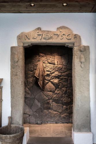 a stone fireplace with a sign on the wall at Charmehotel Uhrerhof - Deur in Ortisei