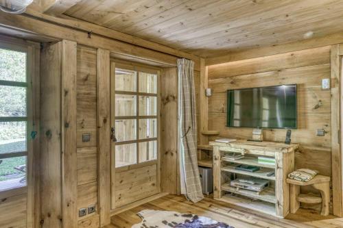 une pièce avec des murs en bois, une télévision et un bureau dans l'établissement Chalet Altitude, à Megève