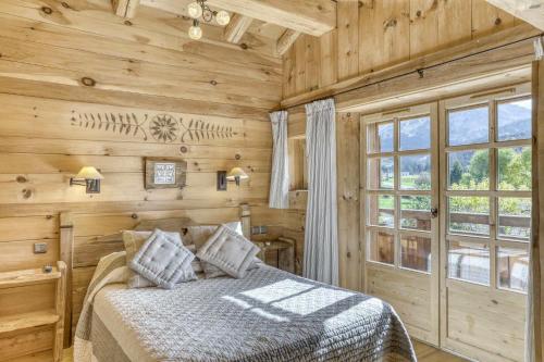 une chambre avec un lit et une grande fenêtre dans l'établissement Chalet Altitude, à Megève
