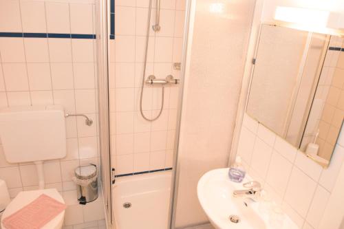 a bathroom with a shower and a toilet and a sink at Landgasthof Kasch - Hotel und Restaurant in Malente