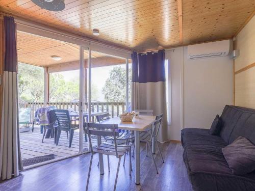 un salon avec un canapé, une table et des chaises dans l'établissement Chalet 3 étoiles - eeicci, à Cargèse