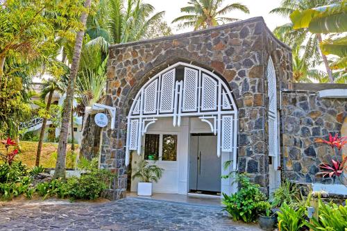 an entrance to a stone building with a white door at Seasense Boutique Hotel & Spa in Belle Mare