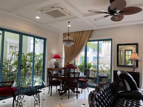 un soggiorno con tavolo, sedie e ventilatore a soffitto di Villa La Bella Phan Thiet a Phan Thiet