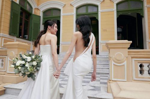 two women in wedding dresses standing outside a building at W Bangkok Hotel in Bangkok