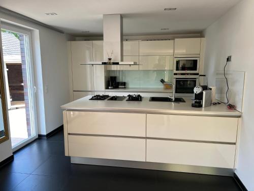 a kitchen with white cabinets and a counter top at Ferienhaus Celeste in Warnemünde