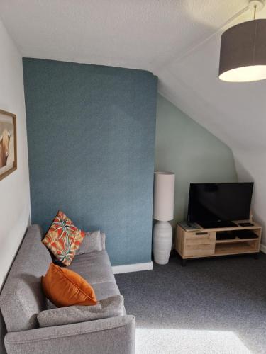 a living room with a couch and a tv at The Loft, Inverness in Inverness