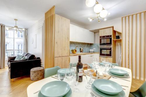 - une cuisine et un salon avec une table et des verres à vin dans l'établissement 223 Suite Rothschild - Superb apartment in Paris, à Paris