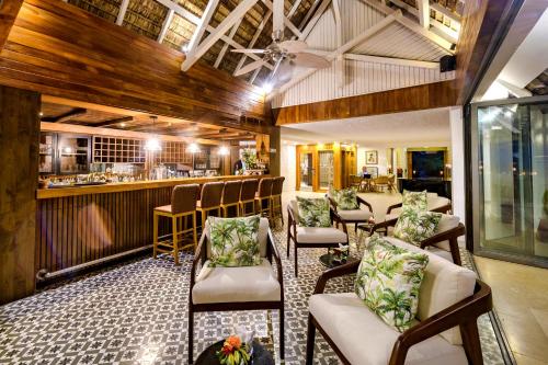 a restaurant with chairs and a bar in the background at Seasense Boutique Hotel & Spa in Belle Mare