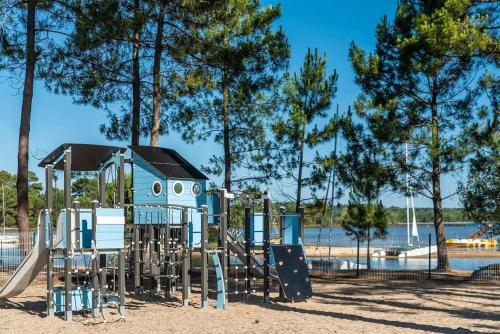 - une aire de jeux dans un parc à côté d'une étendue d'eau dans l'établissement Camping 4 étoiles - Parc aquatique - eeic0i, à Biscarrosse