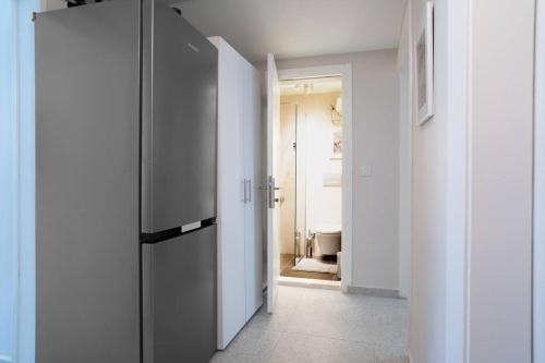 a hallway with a black refrigerator in a white room at Modern and Designed 2BR W Garden in Adalar