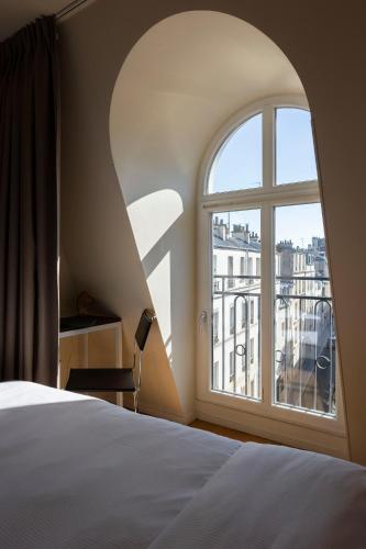 une chambre avec une fenêtre avec vue sur une ville dans l'établissement Hôtel Cabane - Orso Hotels, à Paris