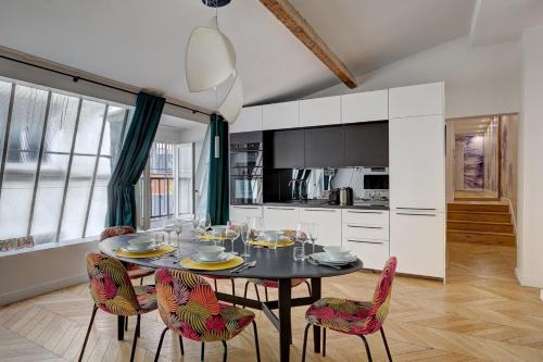 une salle à manger avec une table et des chaises dans une cuisine dans l'établissement 265 Suite Antoine - Superbe Appartement à Paris, à Paris