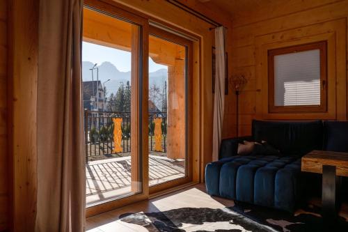 een woonkamer met een bank en een groot raam bij Przewodnicka Chata in Kościelisko