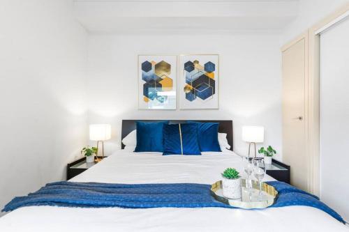 Un dormitorio con una cama grande con almohadas azules. en The Cornerstone on Inkerman, en Melbourne