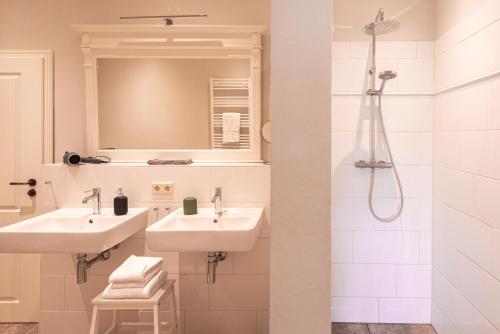a bathroom with two sinks and a shower at Storchenhof Blumenow in Blumenow
