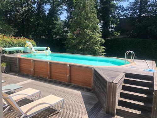 - une piscine avec une terrasse et des chaises à côté dans l'établissement Villamélie, à Carquefou