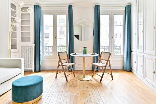 un salon avec une table et des chaises dans l'établissement Appartement Haussmannien lumineux et central- II, à Paris