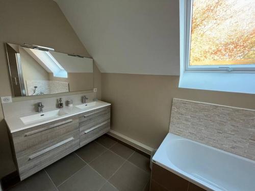 une salle de bain avec un lavabo et un miroir dans l'établissement Villamélie, à Carquefou