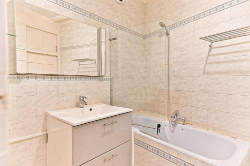 une salle de bain avec un lavabo, une baignoire et une douche dans l'établissement Appartement Haussmannien lumineux et central- II, à Paris