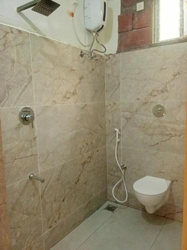 a bathroom with a shower and a toilet at The Hills Studio Appartment in Tiruvannāmalai