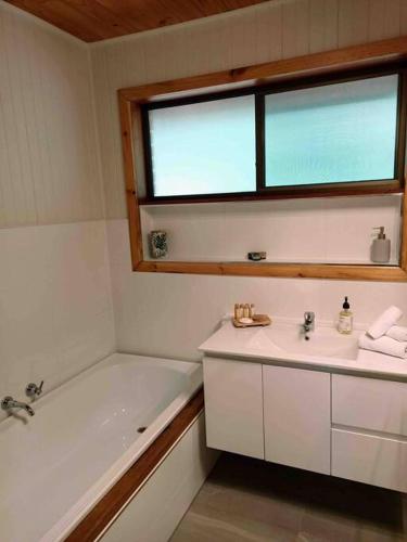 a bathroom with a sink and a tub and a window at Honeycomb Hill of Yarra Valley in Steels Creek