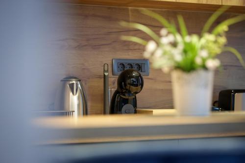 a kitchen counter with a clock and a vase of flowers at Nest Suites in Skopje