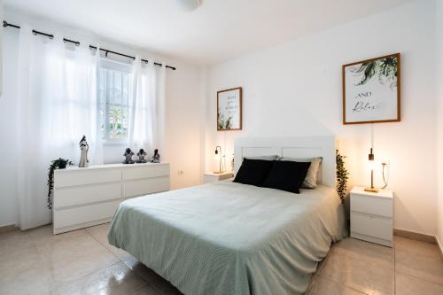 a white bedroom with a large bed and windows at La Posadilla in Adeje