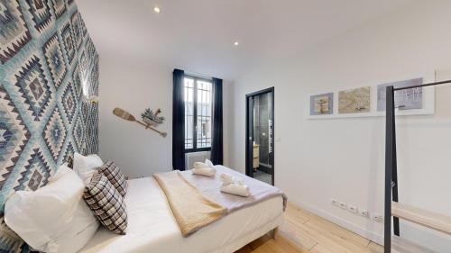 une chambre avec un lit avec deux serviettes dessus dans l'établissement 126 Suite Abraham - Superbe Appartement à Paris, à Paris