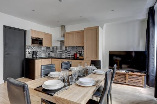 une table de salle à manger avec des chaises et une cuisine dans l'établissement 126 Suite Abraham - Superbe Appartement à Paris, à Paris