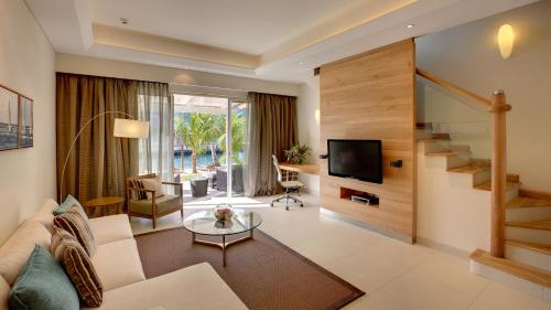 a living room with a couch and a tv at Le Suffren Hotel & Marina in Port Louis