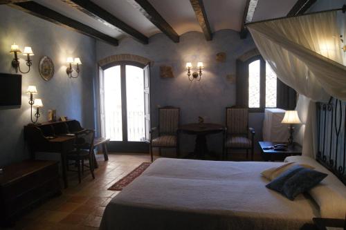 1 dormitorio con 1 cama, mesa y sillas en Hostal La Panavera, en Perelló