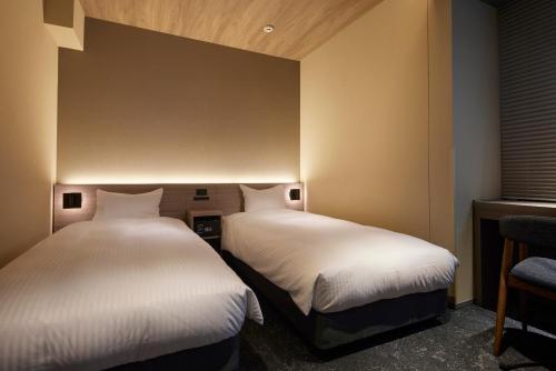 two beds in a small room with two beds sidx sidx sidx at Minn Asakusa Kuramae Station in Tokyo
