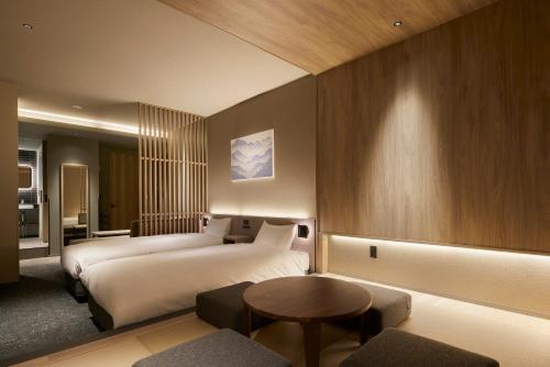 a hotel room with two beds and a table at Minn Asakusa Kuramae Station in Tokyo