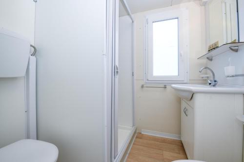 a white bathroom with a shower and a sink at Campeggio Europa Silvella in San Felice del Benaco