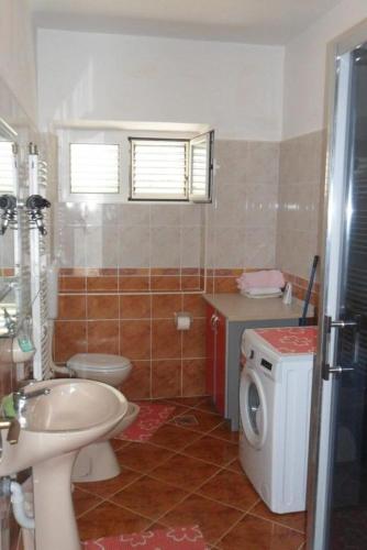 a bathroom with a toilet sink and a washing machine at Apartment Ralje in Sali