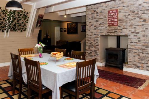 a dining room with a table and a fireplace at STAY In TEHAMA in Cape Town