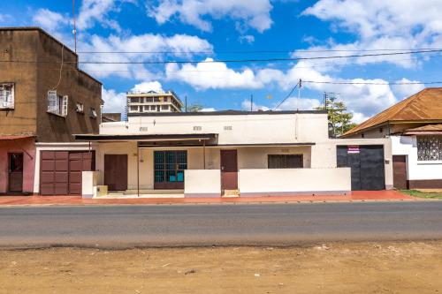 an old white building on the side of a street at Ghala House Apartment Moshi in Moshi