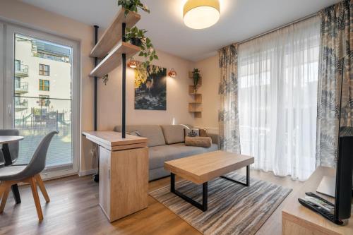 a living room with a couch and a table at RentPlanet - Apartamenty Zakopiańskie in Zakopane