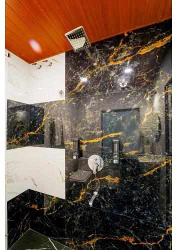 a bathroom with a black and yellow marble wall at Saanjh Riverside Resort in Mahabaleshwar
