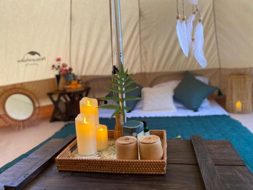 a table with a tray of food and candles on a tent at Zenda Glamping in Bao Loc