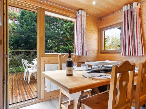 - une salle à manger avec une table et une bouteille de vin dans l'établissement Apartment Le Petit Savoyard-4 by Interhome, à Châtel