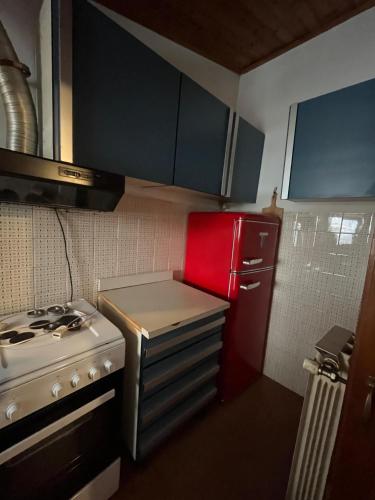a small kitchen with a stove and a red refrigerator at SURSUM CORDA private house in Orvinio
