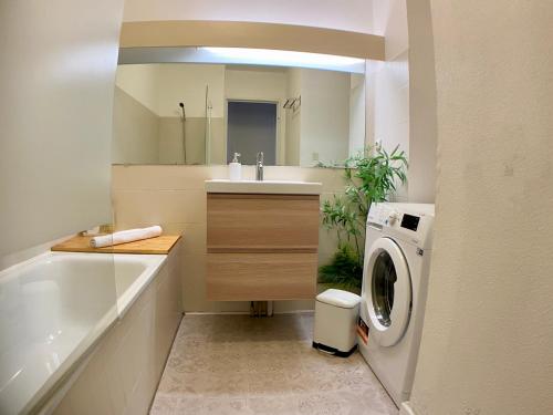a bathroom with a sink and a washing machine at T2 Élégance Vue Mer Palavas-les-Flots in Palavas-les-Flots