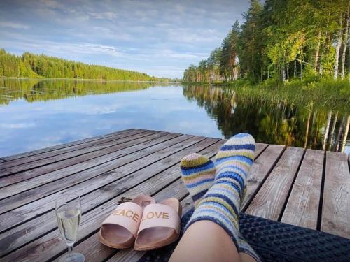 una persona con calzini e scarpe su un molo vicino a un lago di Holiday Home Villa assi by Interhome a Haapamäki