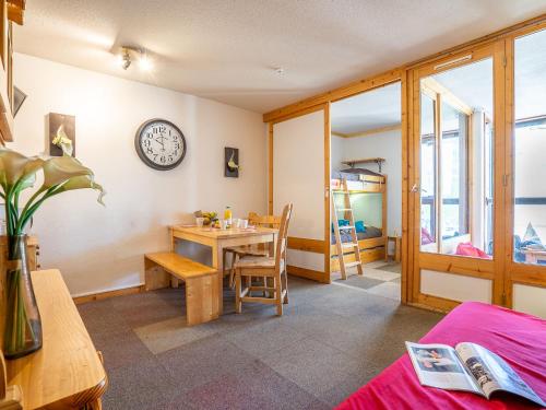 a room with a table and a clock on the wall at Apartment Eskival 106 by Interhome in Val Thorens
