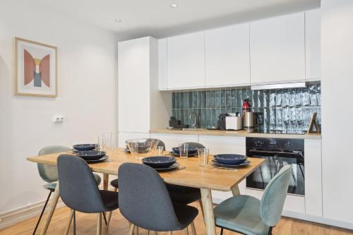 une cuisine avec une table et des chaises en bois dans l'établissement Bluestay 46 - Superbe appartement à Paris, à Paris