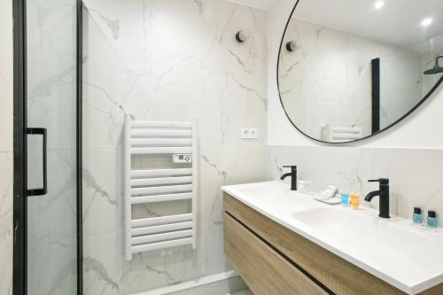une salle de bain avec un lavabo et un miroir dans l'établissement Bluestay 46 - Superbe appartement à Paris, à Paris