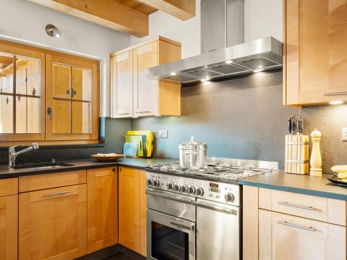 a kitchen with wooden cabinets and a stove top oven at Chalet Godfrey by Interhome in Les Crosets